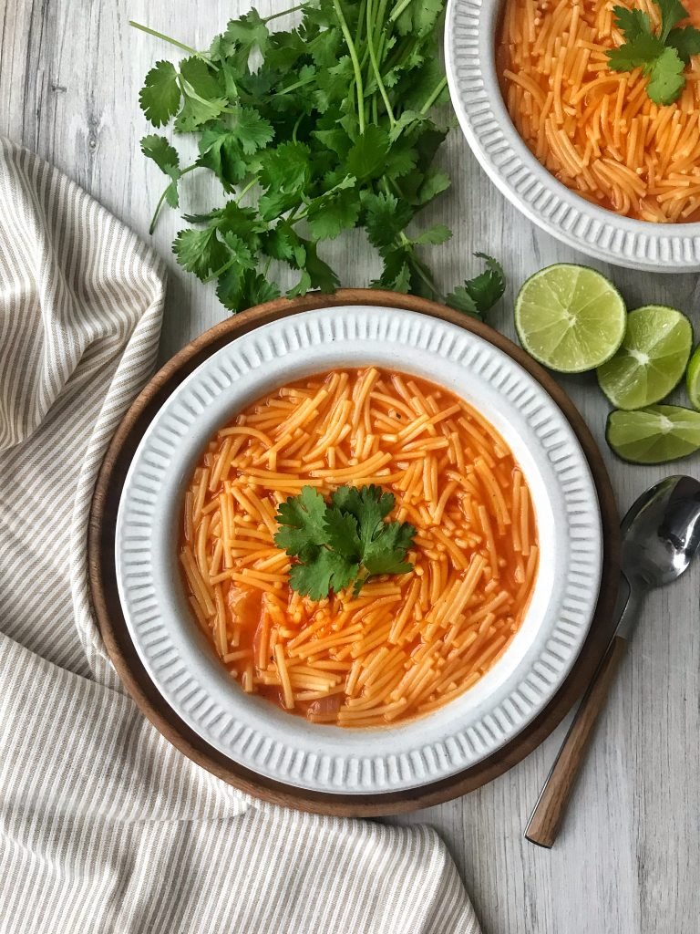 Mexican fideo in a bowl with cilantro and lime garnish