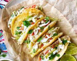 Crispy potato tacos with tomatoes, onions, queso fresco, sour cream, and salsa