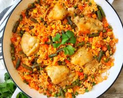 Large white pan with chicken and rice with vegetables