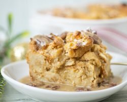 Bread pudding slice on a white plate with brow sugar bourbon sauce