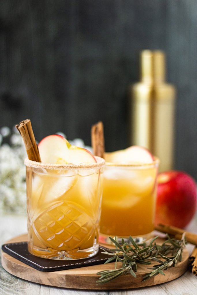 2 glasses of apple cider margaritas. Apple slice and cinnamon stick garnish