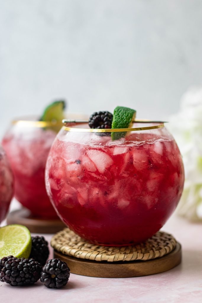 Blackberry Bourbon smash on coaster with lime and blackberry garnish