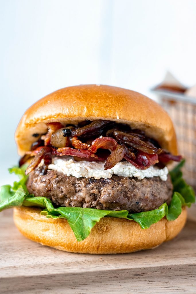 Up close shot of Bacon Goat Cheese Burgers with Balsamic Caramelized Onions.